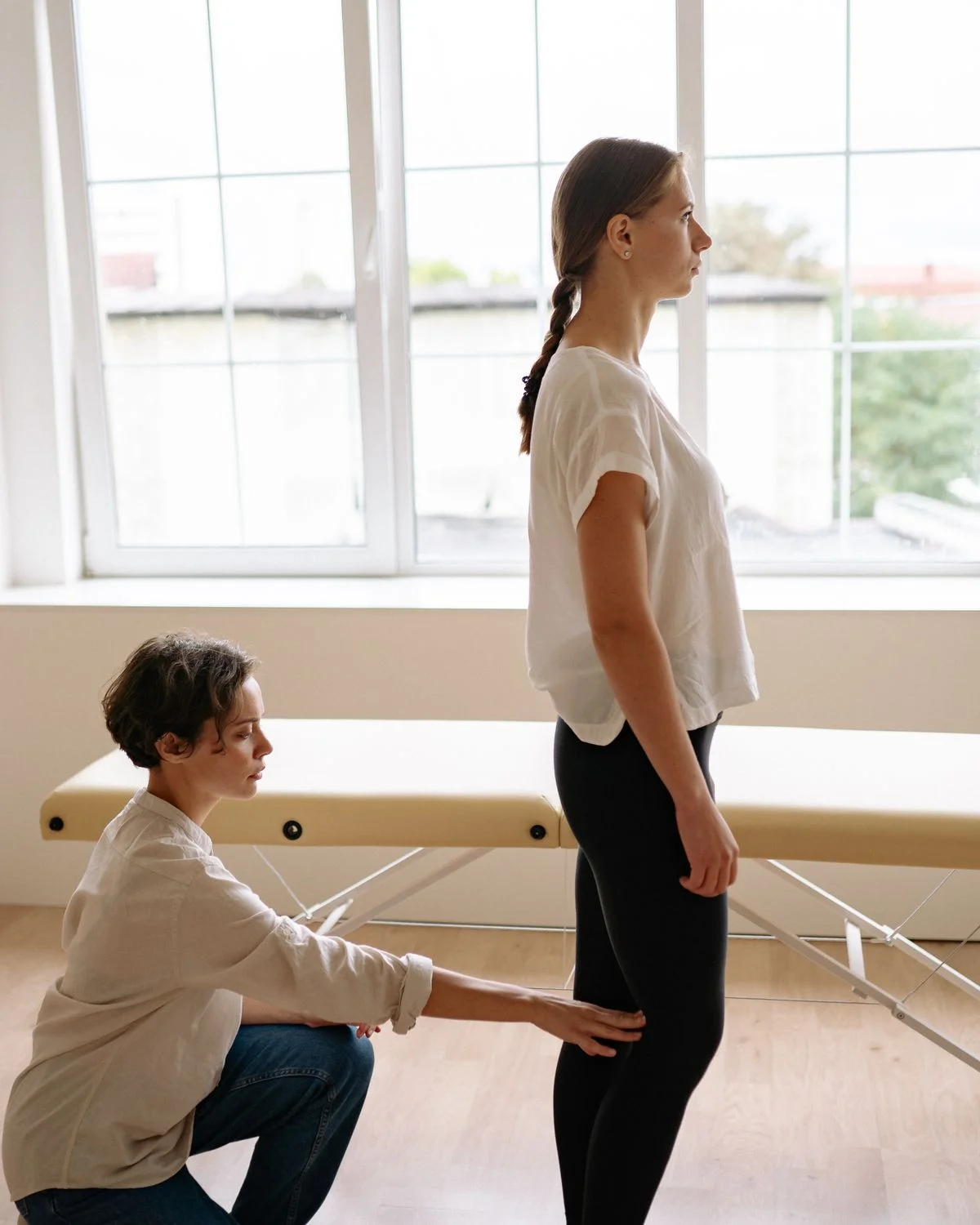 Practitioner guiding precise movement in a sunlit studio